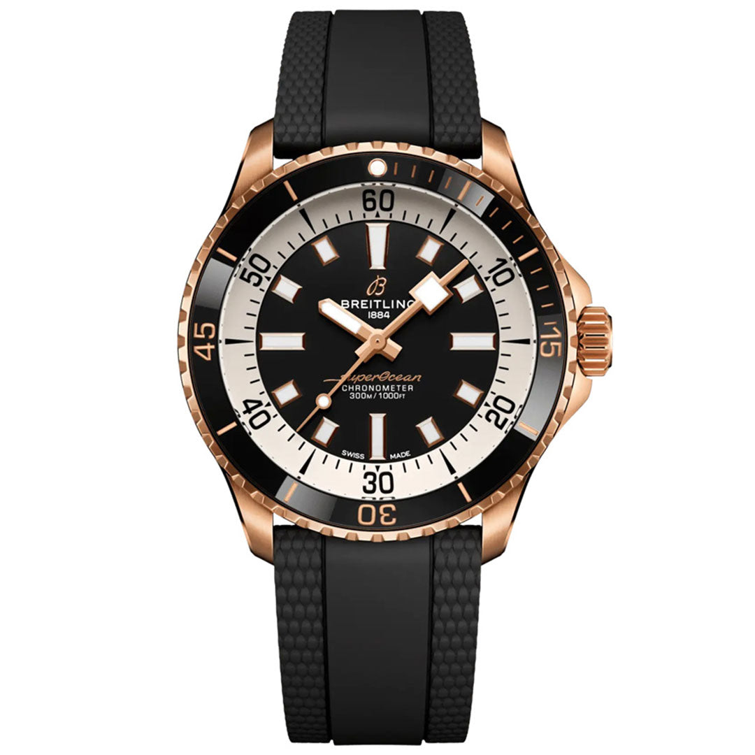 The BREITLING Superocean Automatic 42 by Breitling is a dive watch featuring a black dial, gold case, black bezel, and a black textured rubber strap, with white hour markers and hands.