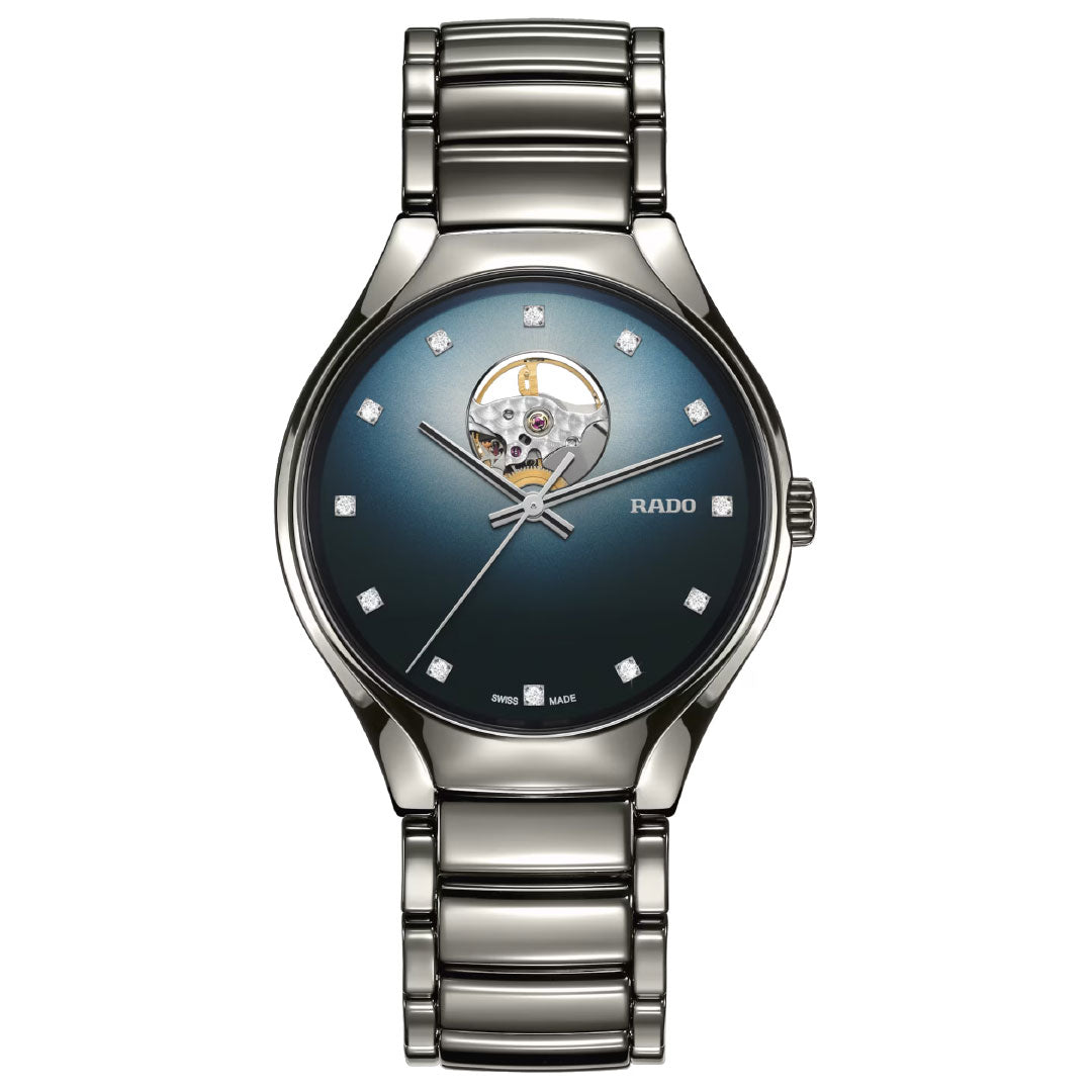 The RADO True Round Secret Diamonds Automatic 40mm Watch features a metallic strap, blue gradient dial, silver hour markers, a visible Swiss-made movement at 12 o'clock, and sparkling diamond indices for a sleek, modern look.