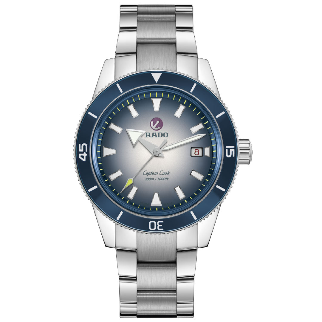 The RADO Captain Cook Automatic 42mm Watch features a stainless steel case, blue bezel, silver gradient dial, luminous hands, date at 3 o'clock, 80-hour power reserve, and is water-resistant up to 300M.