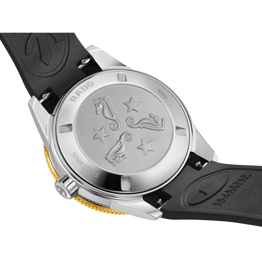 The back of the RADO Captain Cook Automatic 39mm Watch features a black strap, silver case, and engraved seahorses, stars, and waves on the metal case back.