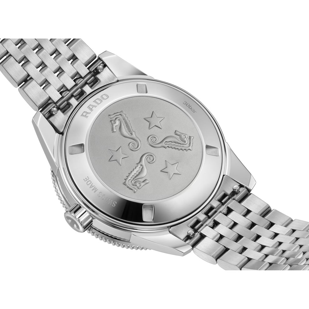The back of the RADO Captain Cook Automatic 39mm Watch, adorned with engraved sea horses and stars on the case back and complemented by a sleek silver metal band, seamlessly blends classic elegance with modern innovation through its high-tech ceramic bezel.