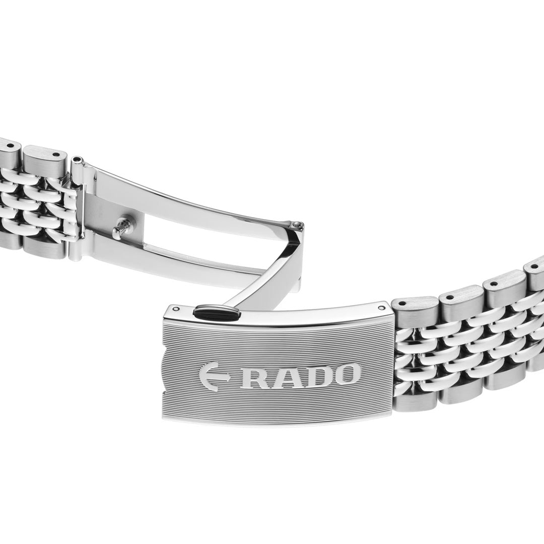 A silver metal watch band with a clasp open, displaying the engraved “RADO” logo on the clasp. The band features multiple rows of polished, rounded links that complement the high-tech ceramic bezel of the RADO Captain Cook Automatic 39mm Watch.