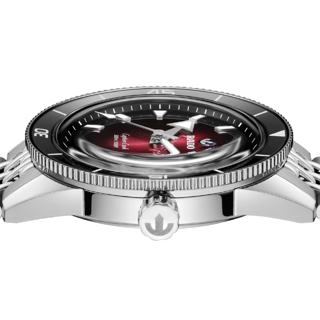 Side view of the RADO Captain Cook Automatic 39mm Watch in silver, featuring a black bezel, domed glass, red and black dial, anchor crown detail, shining metal bracelet, and high-tech ceramic accents showcasing its automatic movement.