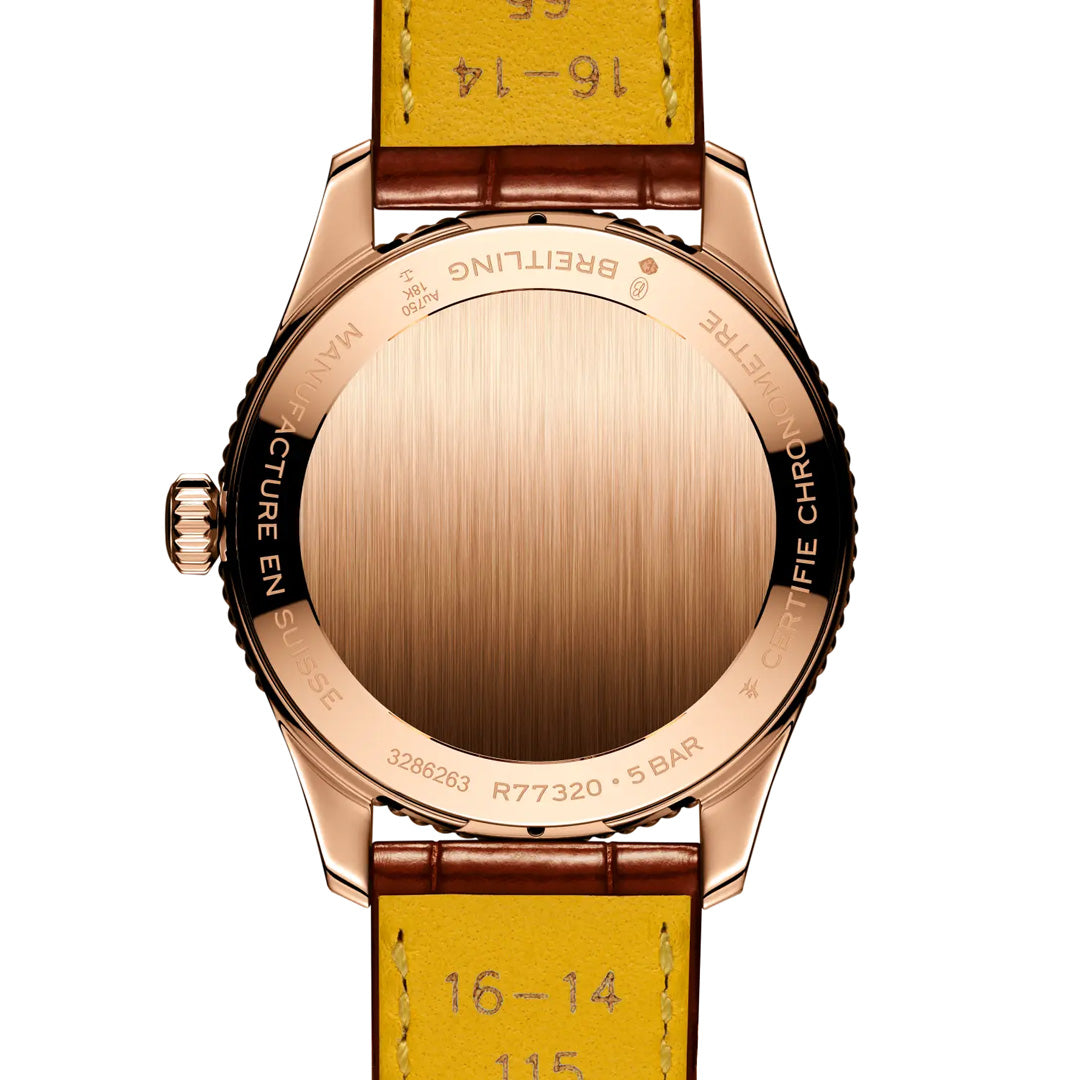 The back of a BREITLING Navitimer 32 by Breitling features a gold case, engraved text along the edge, and a yellow leather strap with measurement markings—a true icon among luxury watches.