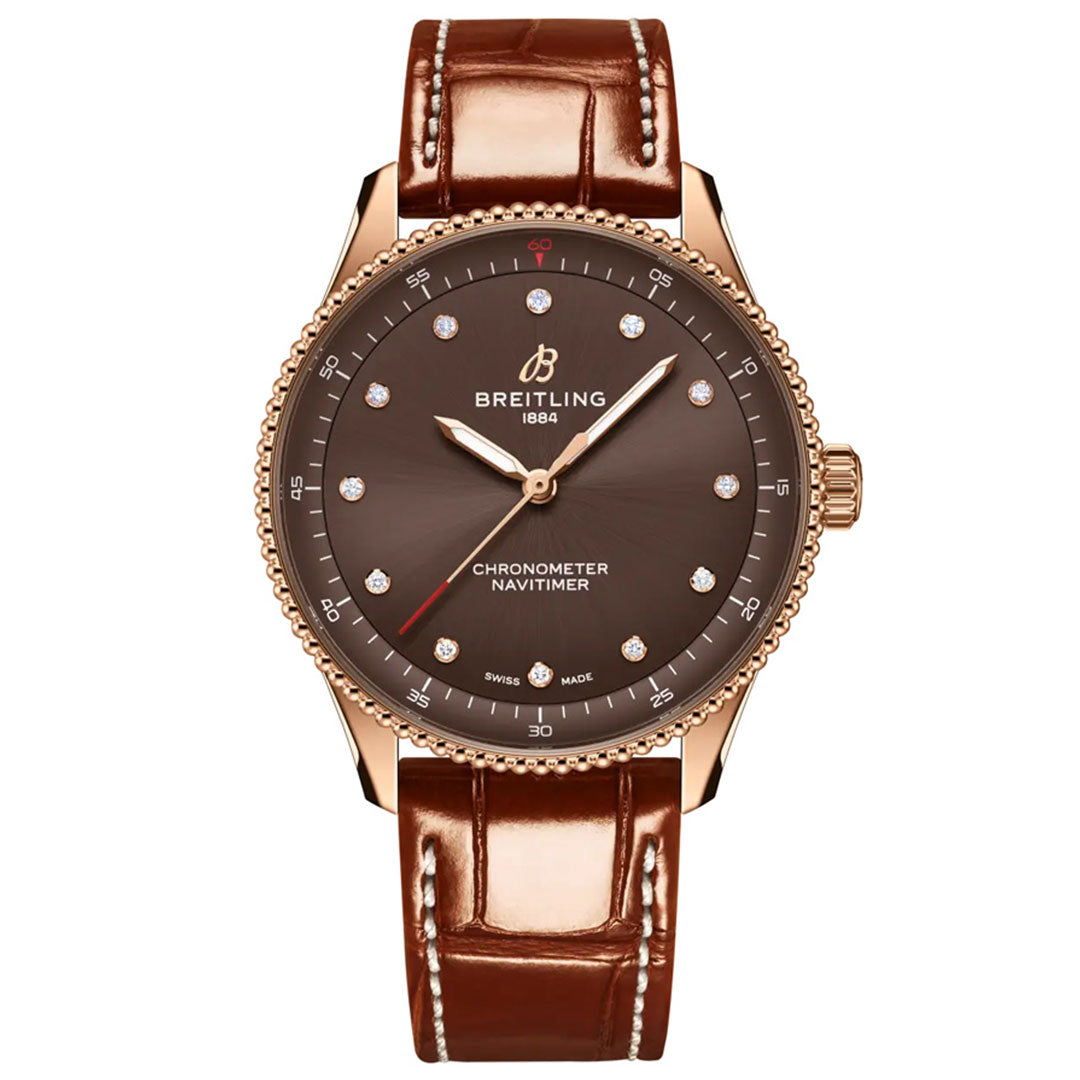 The BREITLING Navitimer 32 by Breitling features a brown dial with diamond hour markers, a gold case, and a brown leather strap, showcased from the front—an exquisite example of luxury watchmaking.