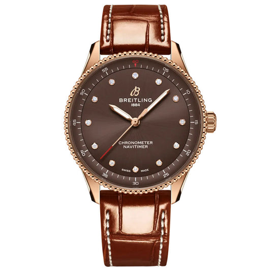 The BREITLING Navitimer 32 by Breitling features a brown dial with diamond hour markers, a gold case, and a brown leather strap, showcased from the front—an exquisite example of luxury watchmaking.