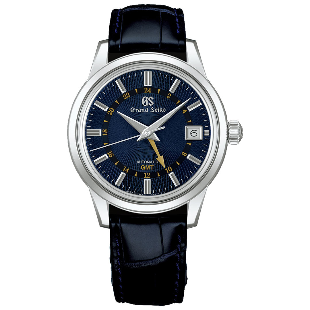 The Grand Seiko Elegance Automatic Mechanical GMT 39.5mm Watch features a dark blue textured dial, silver and gold-tone indices, silver hands, gold GMT hand, date at 3 o’clock, and a refined dark blue leather strap.