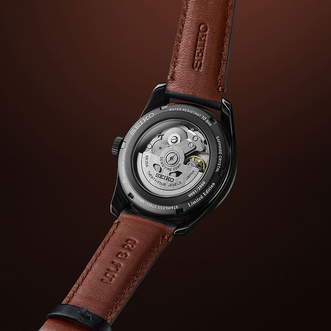 A close-up of the Seiko Presage Sharp Edged Series Kabuki-Inspired Automatic 39mm Limited Edition (2,000 pcs), featuring a brown leather strap and exposed movement on a dark brown backdrop.