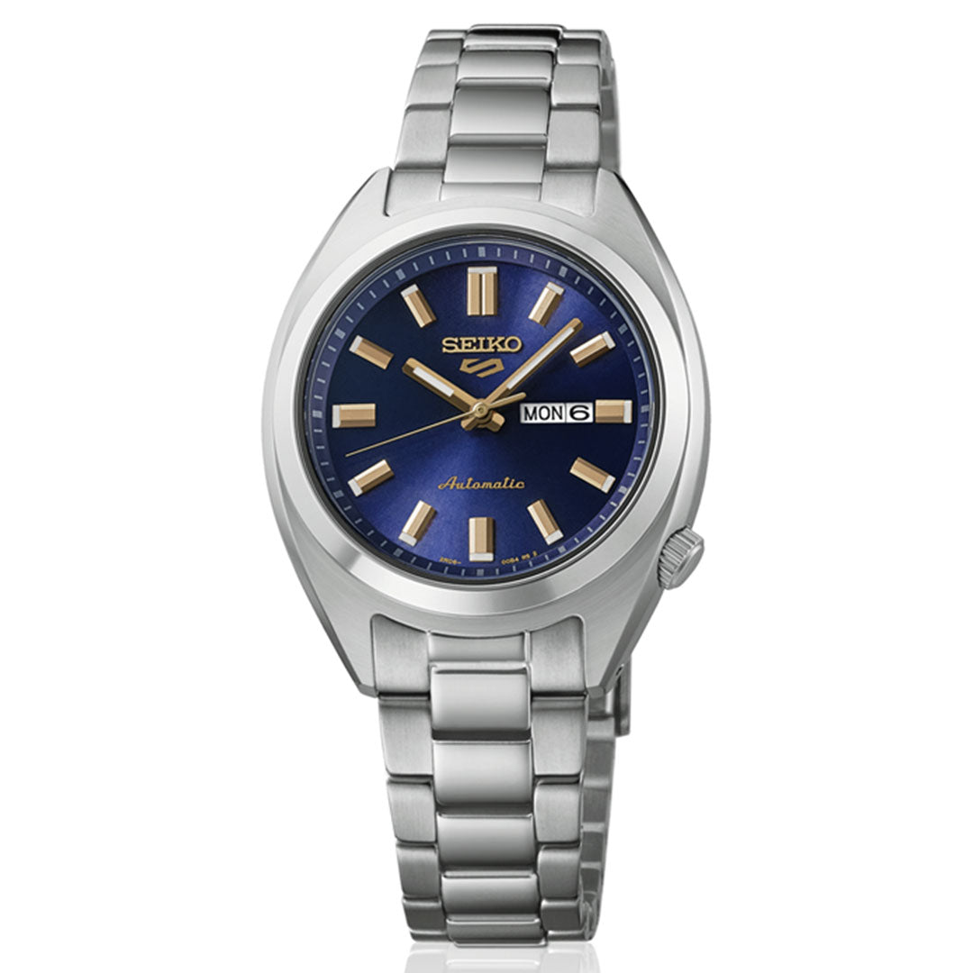 The Seiko 5 Sports SNXS Series Automatic 32mm Watch features a silver metal band, blue dial, gold hour markers and hands, and a day-date window at 3 o'clock displaying "MON 6.