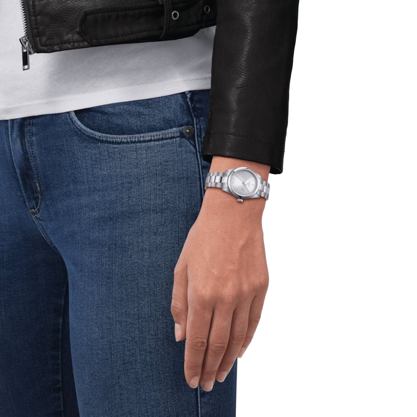 From the waist down, a person dressed in a black leather jacket and blue jeans is seen. Their left hand showcases the Tissot T-My Lady Quartz 29mm watch, featuring Swiss Quartz Movement and a scratch-resistant sapphire crystal.