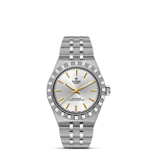 The TUDOR Royal by TUDOR features a silver dial, gold hour markers and hands, fluted bezel, and stainless steel bracelet. This automatic sport-chic wristwatch displays the Tudor logo under 12 o’clock and text above 6 o’clock.