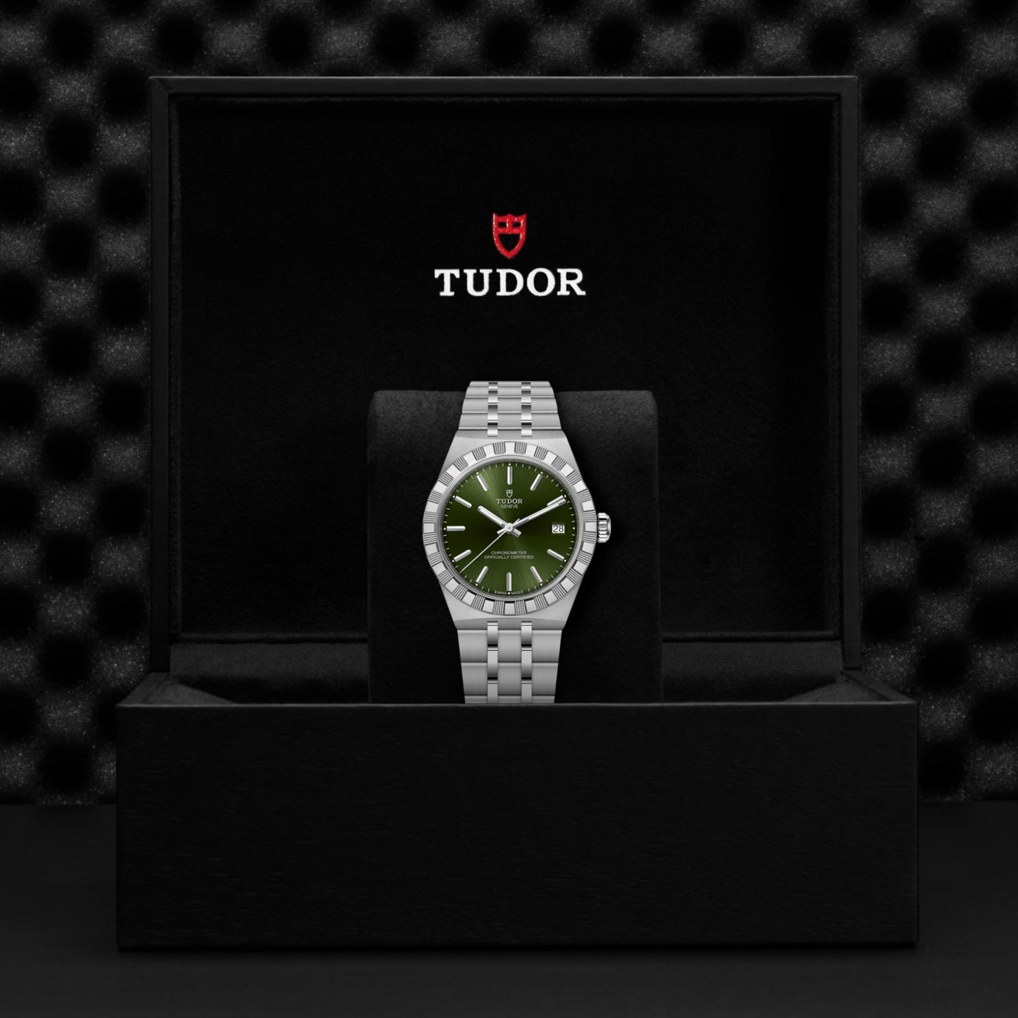 The TUDOR Royal wristwatch, by TUDOR, features a silver stainless steel design and green dial. Presented on a black cushion in a branded box, it highlights the sporty elegance and durability of automatic sport-chic watches.