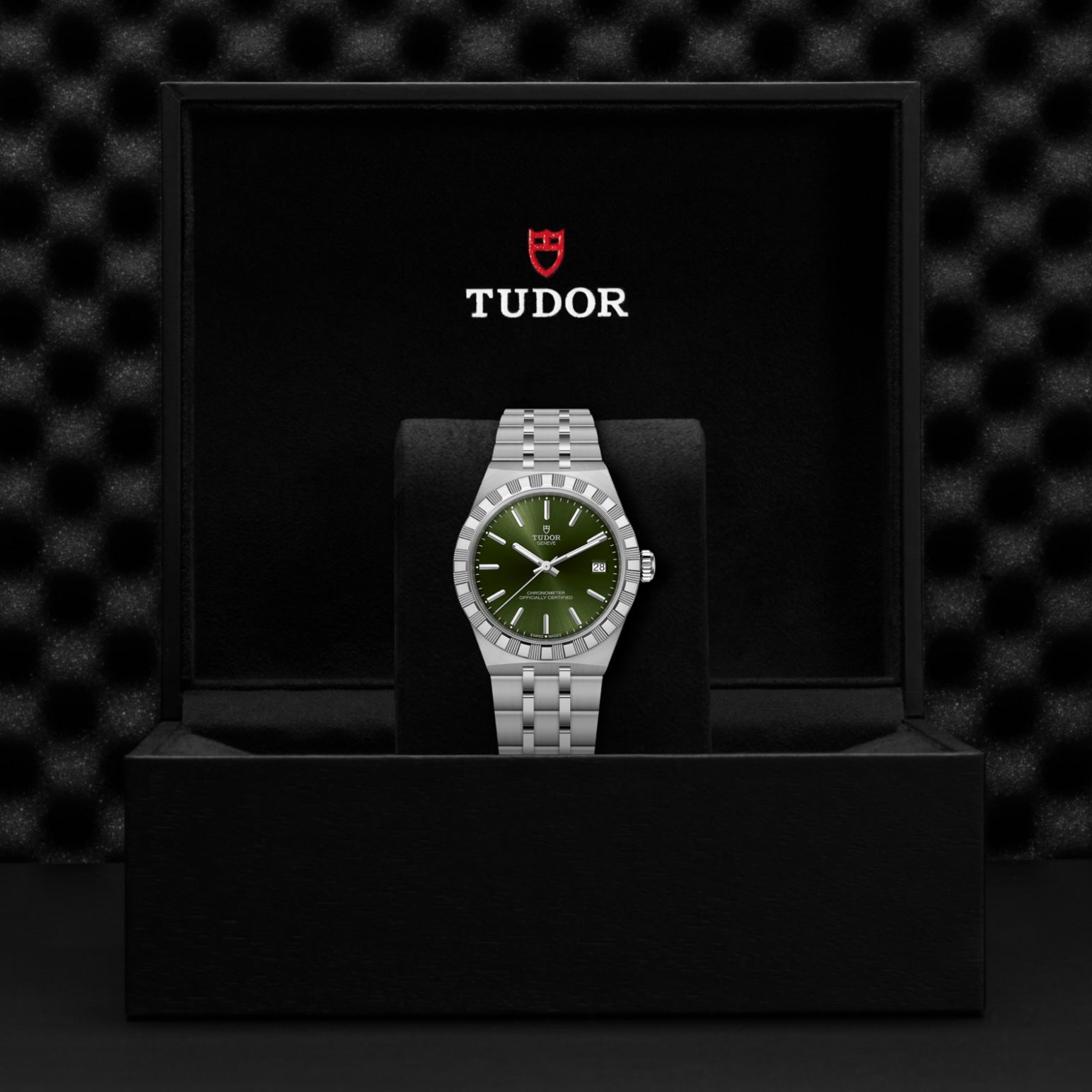 The TUDOR Royal wristwatch, by TUDOR, features a silver stainless steel design and green dial. Presented on a black cushion in a branded box, it highlights the sporty elegance and durability of automatic sport-chic watches.
