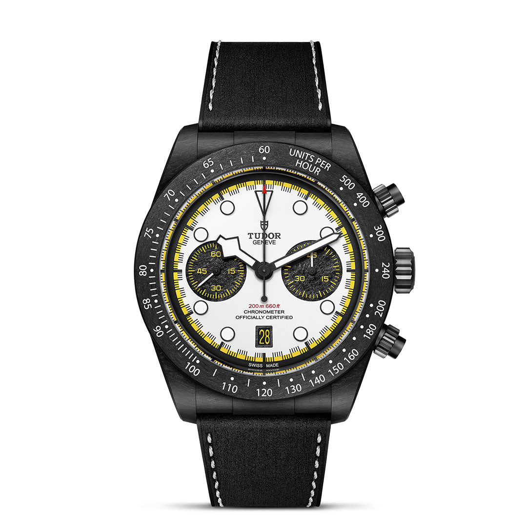 The TUDOR Black Bay Chrono features a black case, white dial with yellow accents, black sub-dials, tachymeter bezel, date at 6 o’clock, and a black leather strap with white stitching—an elegant yet sporty TUDOR chronograph.