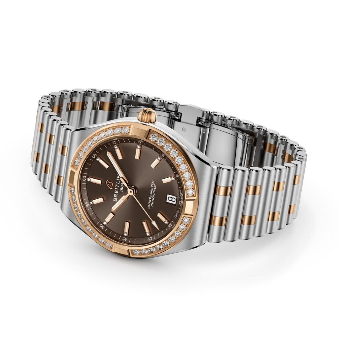 The BREITLING Chronomat Automatic 36 is a luxury Breitling sports watch with a two-tone silver and rose gold band, brown dial, diamond-accented bezel, COSC-certified precision, and date at 6 o’clock.