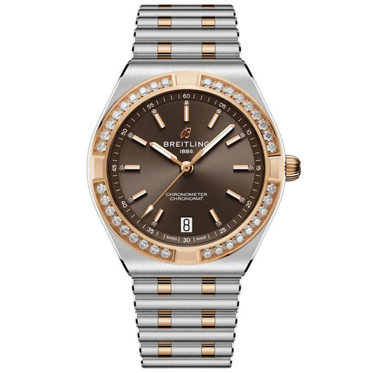 The BREITLING Chronomat Automatic 36 is a luxury sports watch with a two-tone silver-gold band, brown dial, gold accents, diamond-set bezel, date at 6 o’clock, and "Breitling 1884" at 12—COSC-certified for precision.