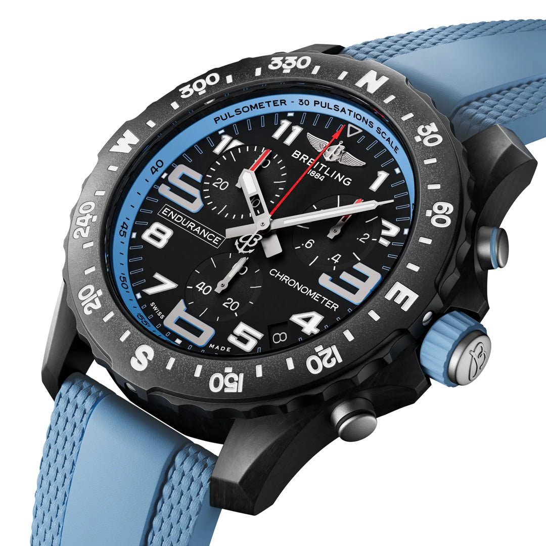 A close-up of the BREITLING Professional Endurance Pro 44, a lightweight Breitling sports chronograph featuring a black dial with white numerals, blue accents, textured light blue rubber strap, pulsometer bezel, and multiple subdials.