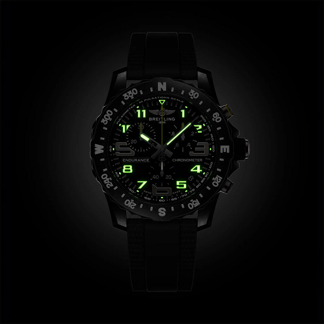 The BREITLING Endurance Pro 44 by Breitling is a black sports chronograph with green luminescent numbers and hands, a compass bezel, durable Breitlight case, and sleek strap—an ideal athleisure watch.