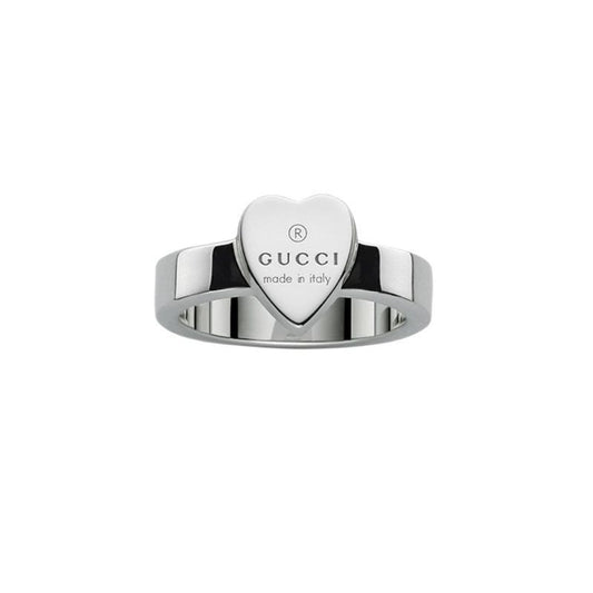 The Gucci Trademark Sterling Silver Ring from GUCCI Fine Jewellery showcases a central heart-shaped design engraved with "GUCCI made in Italy." This love ring is adorned with the iconic Gucci trademark and features a polished, reflective band.
