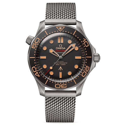 The OMEGA Seamaster Diver 300M Co-Axial Master Chronometer 42mm 007 Edition showcases a black dial with eye-catching orange markers and hands. It includes an orange bezel and is equipped with a textured metal mesh bracelet, expertly crafted in Grade 2 Titanium. This watch is designed for professional diving, as denoted on its dial.