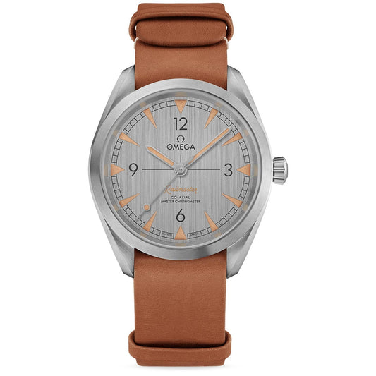 The OMEGA Seamaster Railmaster Co-Axial Master Chronometer 40mm Watch showcases a classic wristwatch design with a silver dial, featuring the OMEGA logo and numerals at the 12 and 6 positions. Constructed from stainless steel, it includes an orange-brown leather strap and a polished metal case, enhanced by triangular hour markers.