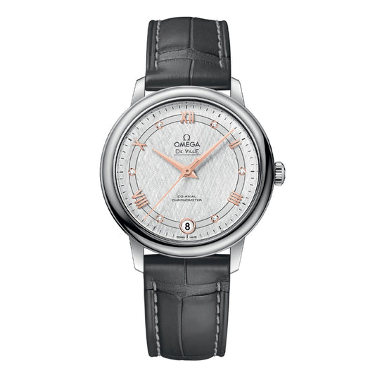 The OMEGA De Ville Prestige Co-Axial Chronometer 32.7mm Watch is a luxurious timepiece featuring a silver round dial adorned with rose gold Roman numerals and complemented by a gray leather strap. It includes a date display at the 6 o'clock position and is equipped with the OMEGA Co-Axial Chronometer Calibre 2500 for outstanding precision.