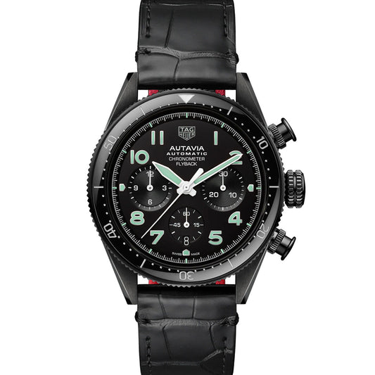 The TAG Heuer Autavia Flyback Chronometer Automatic 42mm Watch by TAG Heuer features a black round face with three sub-dials, luminous hands, and Arabic numerals, powered by an automatic Calibre Heuer 02 movement. It comes with a black leather strap.