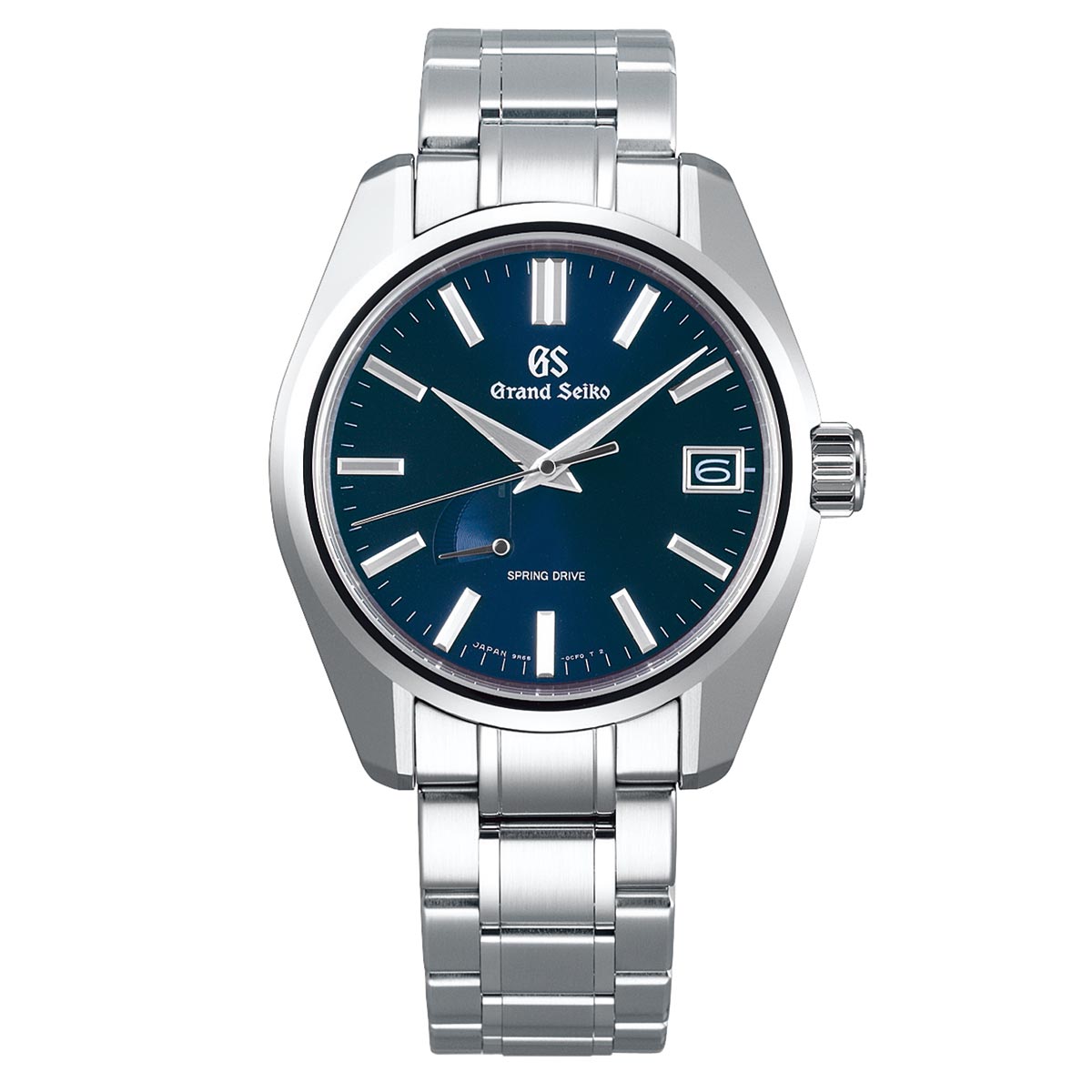 The Grand Seiko Heritage Collection Spring Drive 40mm Watch features a blue dial with luminescent hour markers and hands, a date window at the 3 o'clock position, and the "Spring Drive" label positioned above 6 o'clock. It includes a stainless steel case and metal bracelet.