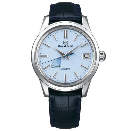 A fashionable Grand Seiko Elegance Collection Spring Drive 40.2mm Watch featuring a snowflake dial, silver hour markers, and hands. The timepiece includes a date display at the 3 o'clock position and is adorned with a blue crocodile leather strap. The brand name "Grand Seiko" and "Spring Drive" are prominently displayed on the refined dial.