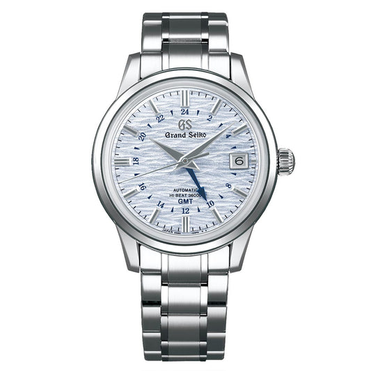 From Grand Seiko's Elegance Collection, this 39.5mm watch features a stainless steel case and a silver metal band, highlighting a textured white dial. It includes silver hour markers, a date window at the 3 o'clock position, and is accentuated by a striking blue second hand. The dial elegantly displays "GMT" and "Automatic.