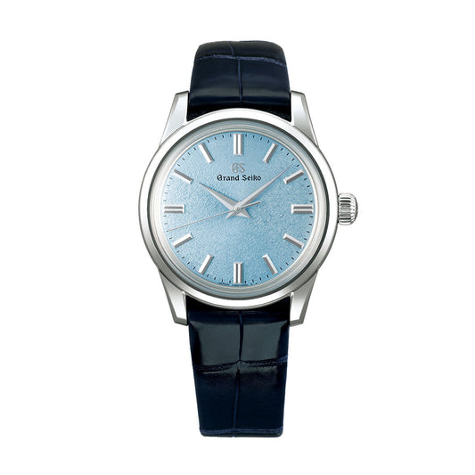 The Grand Seiko Elegance Collection Manual Winding 3-day Power Reserve 37.3mm Watch features a light blue textured dial with silver hour markers and hands. It is powered by the precise Caliber 9S64 movement, housed in a polished stainless steel case, and comes with a dark blue leather strap.