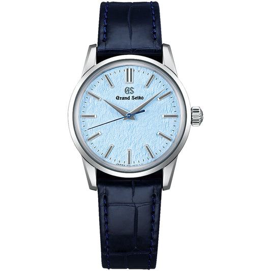 The Grand Seiko Elegance Collection 9F Quartz 34mm Watch showcases a snow-inspired light blue textured dial, silver hour markers, and a meticulously crafted silver case. It includes a blue leather strap accented with edge stitching. The watch hands and the Grand Seiko logo stand out prominently on the dial.